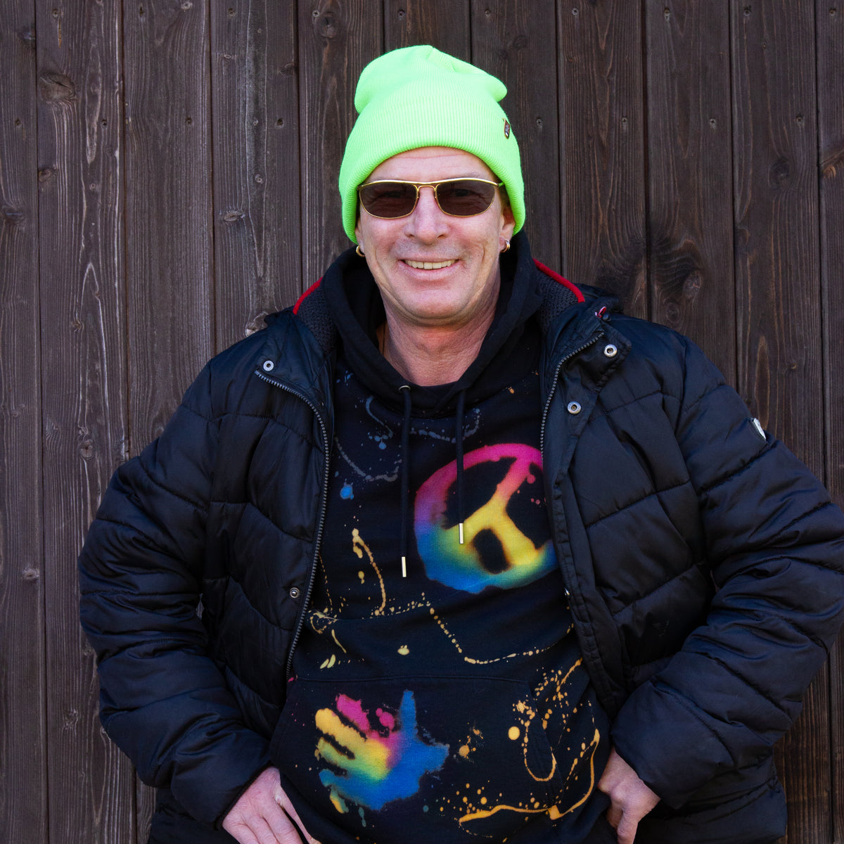 Mann trägt Neon Beanie und Coolen Hoodie