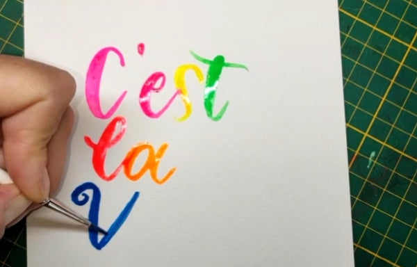 ein Handlettering mit dem Spruch C'est la vie entsteht mit Aquarellfarben und einem Pinsel